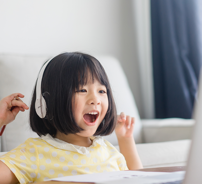 ノートパソコンで学習しながら笑顔を見せる男の子