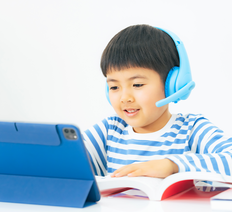 ヘッドセットをつけてタブレットを見ながら学習する男の子
