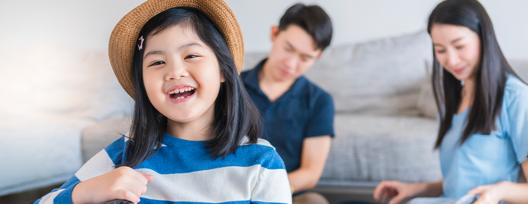 帽子をかぶった女の子と家族がリビングで過ごす様子