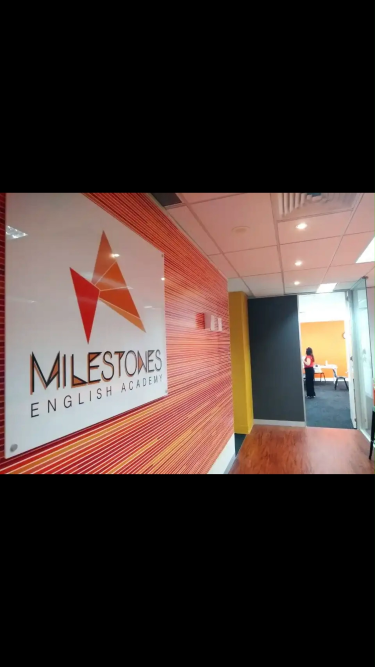 Milestonesロゴが壁に表示された語学学校の屋内廊下