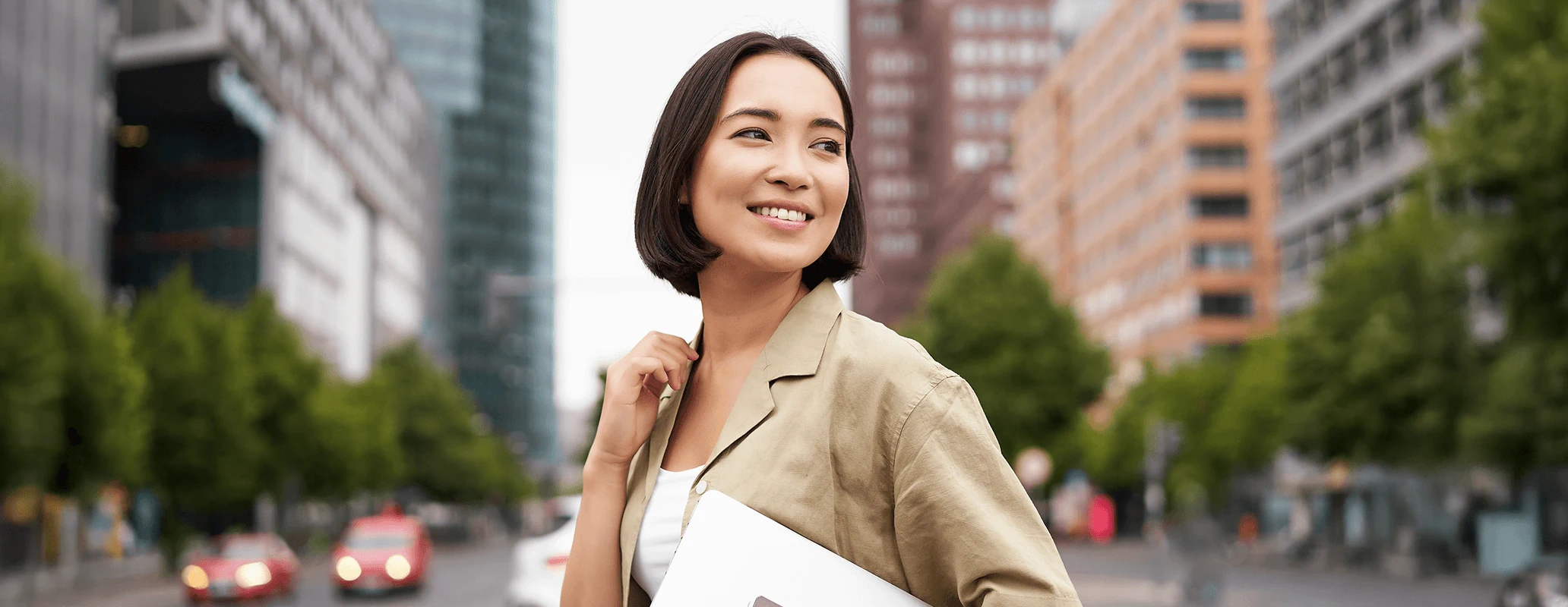 海外の街並みで前向きな表情を浮かべる女性留学生のイメージ
