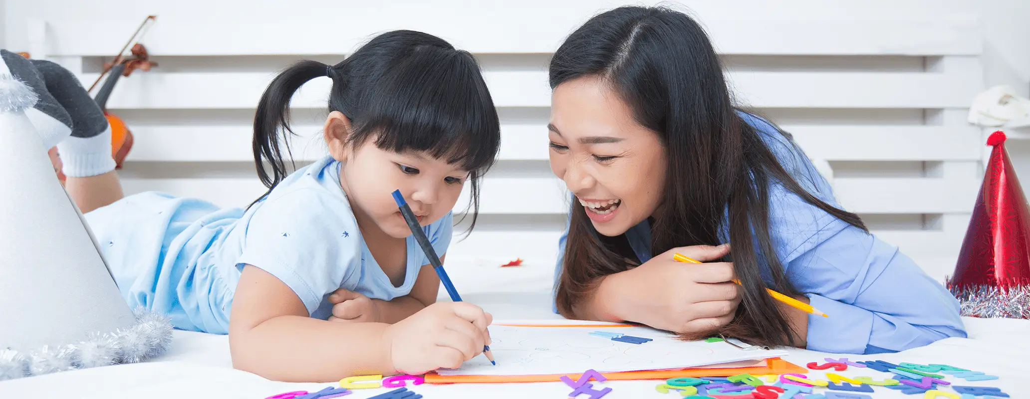 アルファベットを学ぶ子どもと英語学習を見守る母親の様子